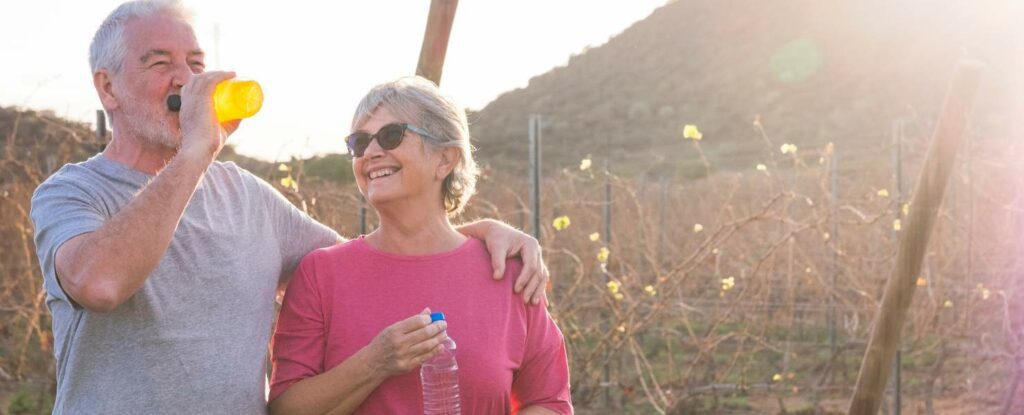 two older adults drinking water to stay hydrated