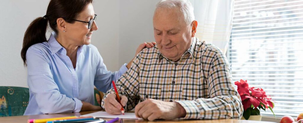 stroke survivor working with a therapist on stroke recovery by writing letters